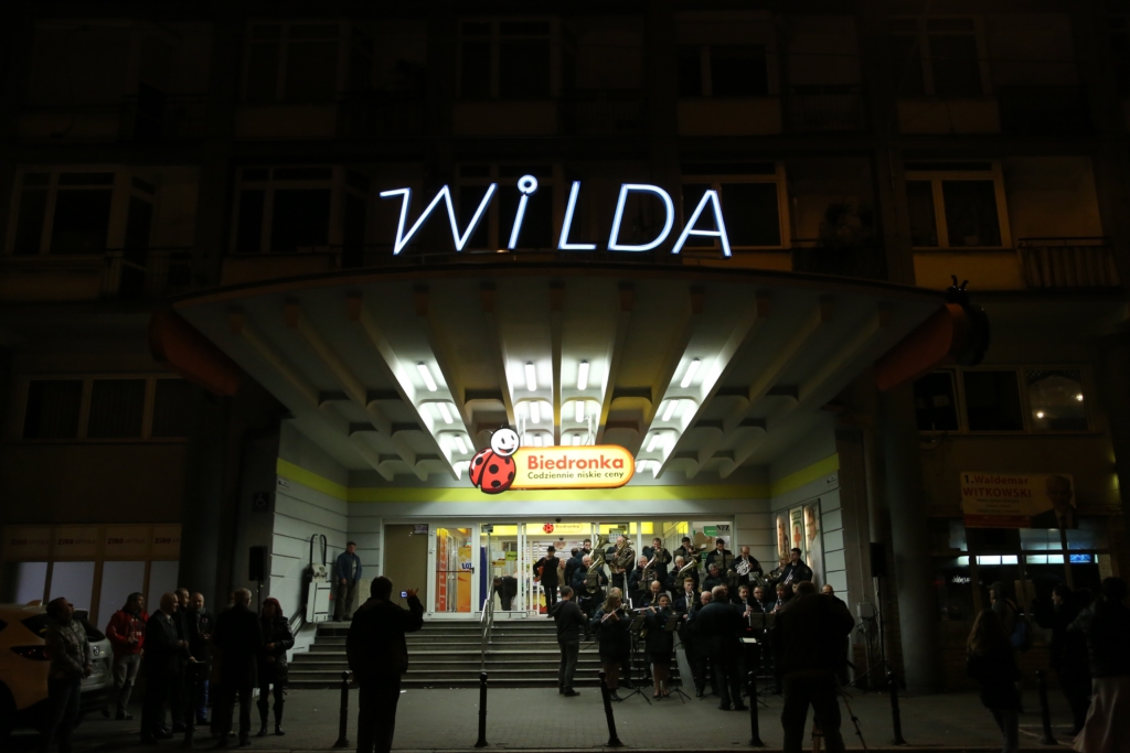 napis &quot;Wilda&quot; na froncie budynku, pod nim napis &quot;Biedronka&quot; i schody do budynku