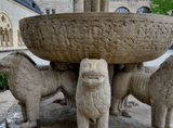 stone fountain supported by lion statues
