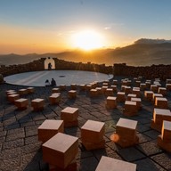 square seats at the amifteater, with mountains and the rising sun in the background