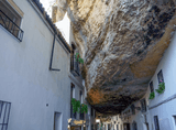 a huge rock among white tenement houses