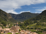 old town buildings with a tall church in a mountain valley
