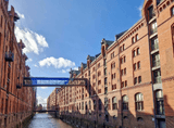 two brick granaries by the river connected by a bridge