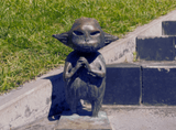 mała figurka skrzata na chodniku