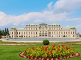 a huge palace with ornaments and a park with flowers