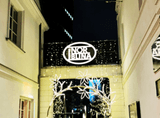 the illuminated sign Fabryka Norblina between the buildings