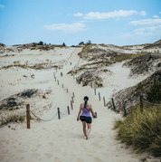 piaskowa góra, na którą wspina się kobieta