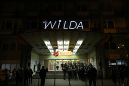 napis &quot;Wilda&quot; na froncie budynku, pod nim napis &quot;Biedronka&quot; i schody do budynku
