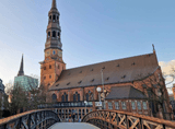 brick church with a tower above the footbridge