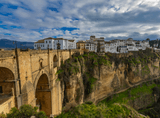 a bridge over a great chasm, with the city visible in the background