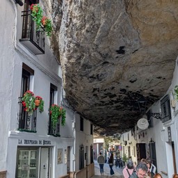 ogromna skała pośród białych kamieniczek