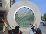 round object with a glass screen in the middle, two motors in front of it