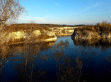 body of water below, surrounded by rocky, overgrown banks