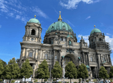 rectangular church building under a large dome, with two towers under the domes