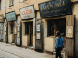 woman walking down a street filled with old signs