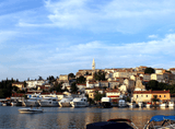 panorama of the city, yachts in the bay, tenement houses and a church in the background
