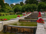 water cascade decorated with flowers, trees and bushes in the background
