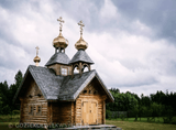 a small wooden church with two towers next to each other