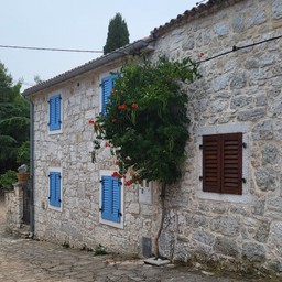 kamienny dom z niebieskimi okiennicami