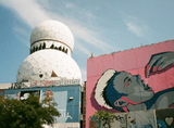 building with two domes on top of each other, next to a building with graffiti