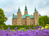 a castle with several turrets surrounded by vegetation