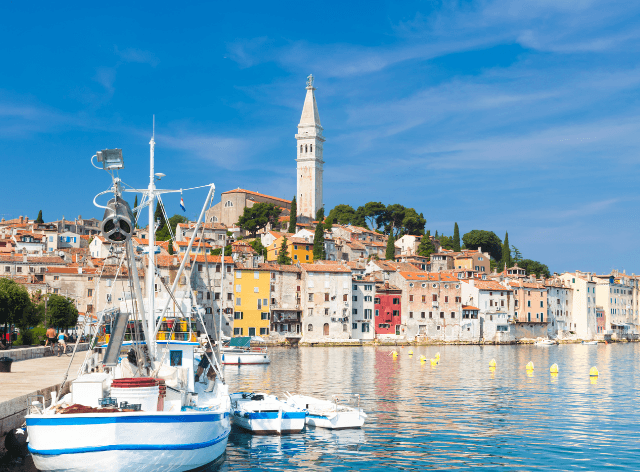 Sailboat on the water, compact urban development in the background