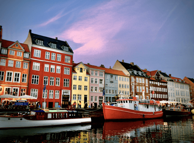 picturesque colourful houses by the water with ships