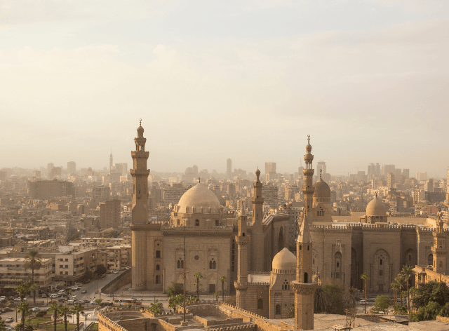 building under a dome with several towers, city in the background